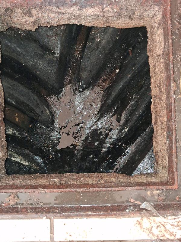 Caixa de esgoto entupida com gordura acumulada